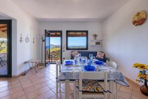 a dining room and living room with a table and chairs at Il Fortino Sea View in Geremèas +14 photos
