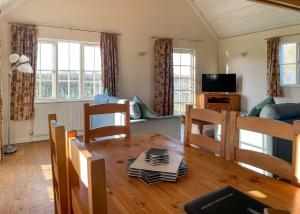 a living room with a table and a couch at Oak Farm Lodges in Roydon