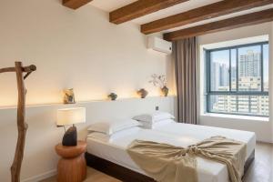a bedroom with a white bed and a window at Lucky Designer Residence Near Bell Tower & City Wall in Xi'an