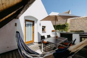a patio with a hammock and a table and an umbrella at Casa.Peiso in Mörbisch am See