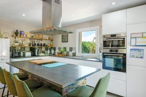 a kitchen with a large table and some chairs at Villa Lailléa avec piscine jacuzzi in Laillé