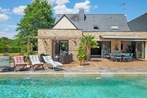 a house with a patio and a swimming pool at Villa Lailléa avec piscine jacuzzi in Laillé