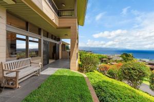 a porch of a house with a bench overlooking the ocean at 1712 Kapalua Home in Kahana