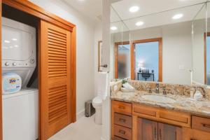 a bathroom with a sink and a toilet and a mirror at 1712 Kapalua Home in Kahana