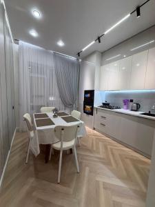 a kitchen with a table and chairs in a room at Жк Prime Park 2 in Shymkent
