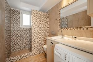 a bathroom with a toilet and a sink and a mirror at Passa Corda Villa in Agios Prokopios +10 photos
