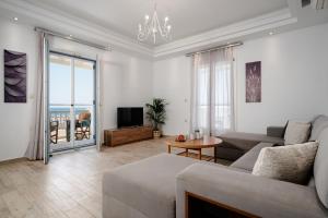 a living room with a couch and a tv at Passa Corda Villa in Agios Prokopios