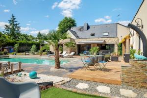 a home with a swimming pool and a house at Villa Lailléa avec piscine jacuzzi in Laillé