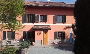 a pink house with a yellow door at Cascina E&E in Costigliole dʼAsti