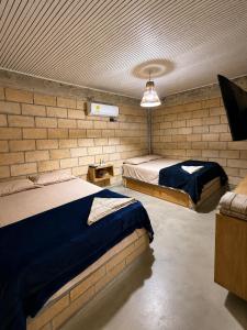 a bedroom with two beds in a brick wall at Hotel Nazareno Coveñas in San Antero +14 photos