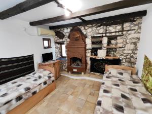 a bedroom with two beds and a stone fireplace at Мехса in Svetoslav