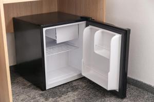an empty refrigerator with its door open in a room at Hotel Ambiance in Prague
