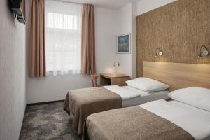 a hotel room with two beds and a window at Hotel Ambiance in Prague