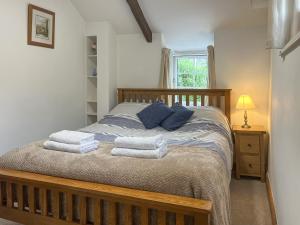 a bedroom with a bed with towels on it at Small Barn - Uk52140 in Liskeard