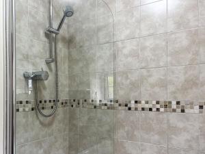 a shower in a bathroom with a glass door at Small Barn - Uk52140 in Liskeard +2 photos