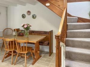 a dining room with a wooden table and stairs at Henwood Barn - Uk52138 in Liskeard