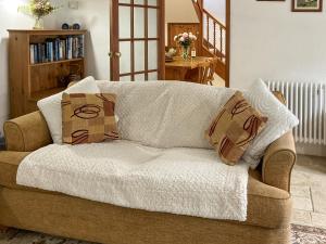 a couch with two pillows on it in a living room at Henwood Barn - Uk52138 in Liskeard +8 photos