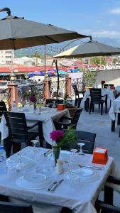 a group of tables and chairs with white tablecloths at Zarina Hotels & Hamam in Batumi