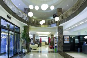 a lobby of a building with a large ceiling at Hotel ILUNION Abando Bilbao in Bilbao