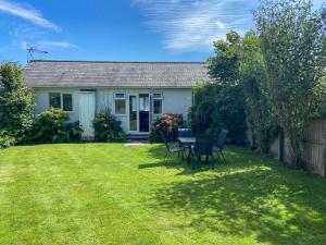 a house with a table and chairs in a yard at Summer Breeze in St Austell +10 photos