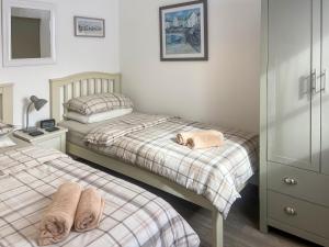 a bedroom with two beds with towels on them at Summer Breeze in St Austell