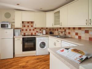 a kitchen with white cabinets and a washing machine at Lark - Ukc6105 in Wootton Fitzpaine +2 photos