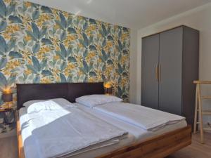 a bedroom with a bed with a floral wallpaper at Vogelkoje - Urlaub an der Nordsee in Nordfriesland in Bredstedt