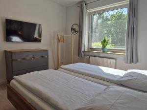 a bedroom with two twin beds and a window at Vogelkoje - Urlaub an der Nordsee in Nordfriesland in Bredstedt