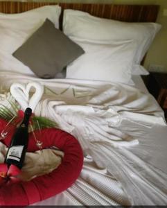 a bed with a bottle of wine and a red plate at Villa Vanilla in Port Glaud