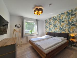 a bedroom with a bed with a floral wall at Vogelkoje - Urlaub an der Nordsee in Nordfriesland in Bredstedt