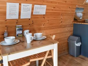 a wooden table with two cups on top of it at Manx View-Uk1396 in Corney