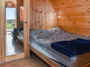 a bed in a room with a wooden wall at Manx View-Uk1396 in Corney