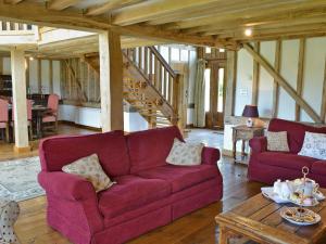 a living room with a purple couch and a table at Romden Barn in Smarden