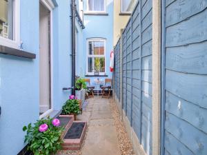 a small alley with a blue wall and a table at Beachcombers Retreat in Felixstowe