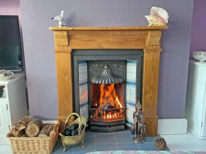 a fire in a fireplace in a living room at Beachcombers Retreat in Felixstowe