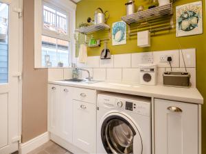 a kitchen with a washing machine and a sink at Beachcombers Retreat in Felixstowe +10 photos