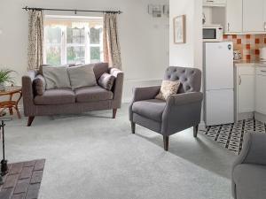 a living room with a couch and a chair at Owl - Ukc6107 in Wootton Fitzpaine +4 photos