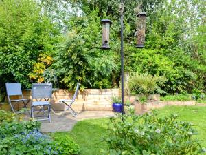 two chairs and a light pole in a garden at Keldholme Cottages 2 - Uk11488 in Kirkbymoorside