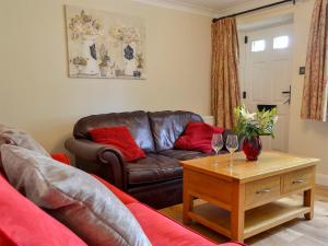 a living room with a couch and a table with wine glasses at Keldholme Cottages 2 - Uk11488 in Kirkbymoorside