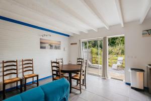 a living room with a blue couch and a table and chairs at Gites de l'hivet in Merdrignac