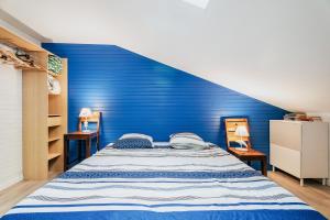 a bed with a blue headboard in a bedroom at Gites de l'hivet in Merdrignac