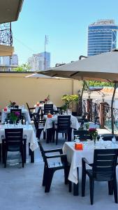 a group of tables and chairs with white tables and umbrellas at Zarina Hotels & Hamam in Batumi