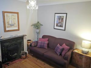 a living room with a couch and a fireplace at Dragonfly Cottage in Beverley