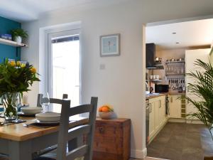 a kitchen with a table and a dining room at Dragonfly Cottage in Beverley
