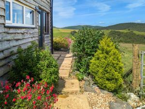 a pathway leading to a house with flowers at Cowlas in Aberhosan