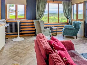 a living room with a couch and two chairs and windows at Cowlas in Aberhosan