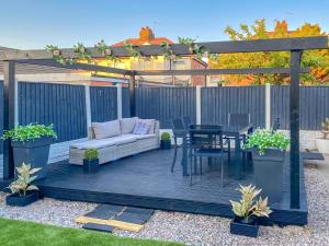 a patio with a couch and a table and a pergola at Wharfdale Lodge in Thornton