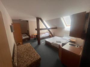 a small room with two beds and a window at Sudický Dvur in Boskovice