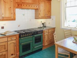 a kitchen with a green stove and wooden cabinets at Hall Teasses Lodge - Uk52175 in Leven