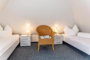 a room with two beds and a chair and two night stands at Ferienhaus 50009 in Carolinensiel
